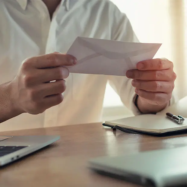 Man holding an envelope, getting ready to mail a payment to OUC.