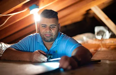 OUC conservation specialist inspects the roof of a home