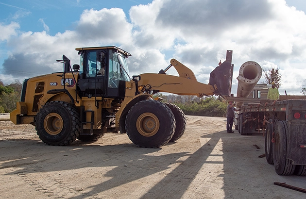 OUC employees move the concrete poles into trucks for transportation